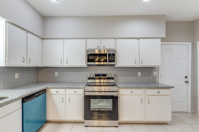 kitchen with stainless steel appliances, white cabinetry, and decorative backsplash