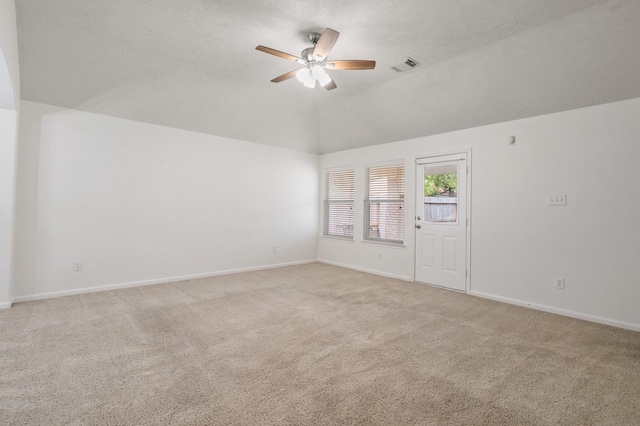 carpeted spare room with lofted ceiling, ceiling fan, and a textured ceiling