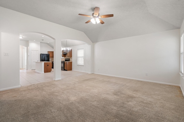 unfurnished living room featuring light carpet, a textured ceiling, lofted ceiling, and ceiling fan with notable chandelier