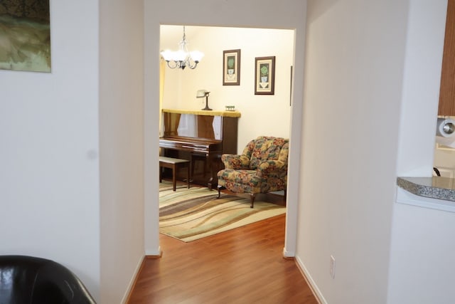 corridor featuring wood-type flooring and a chandelier