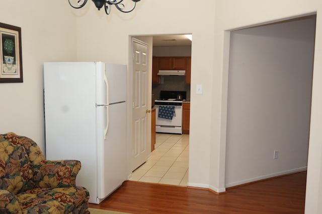 kitchen featuring light tile patterned floors, white appliances, and decorative backsplash