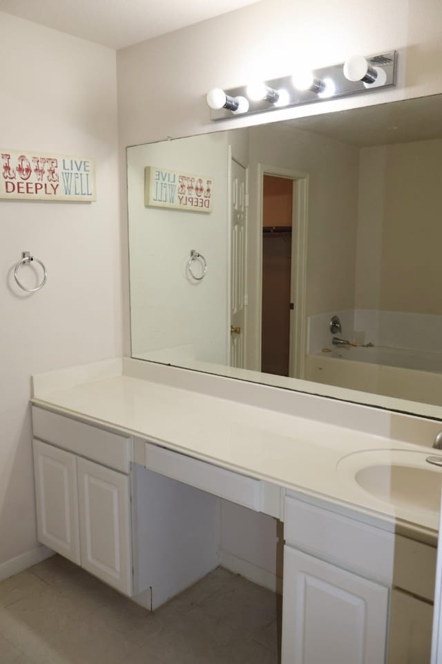 bathroom featuring vanity, tile patterned floors, and a tub to relax in