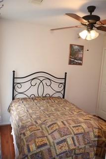 bedroom featuring hardwood / wood-style floors and ceiling fan