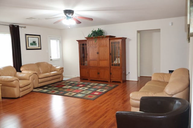 living room with dark hardwood / wood-style floors, a wealth of natural light, and ceiling fan