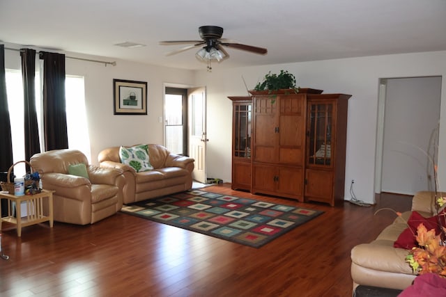 living room with dark wood-type flooring and ceiling fan