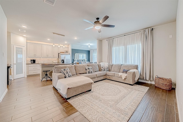 living room featuring ceiling fan and light wood-type flooring