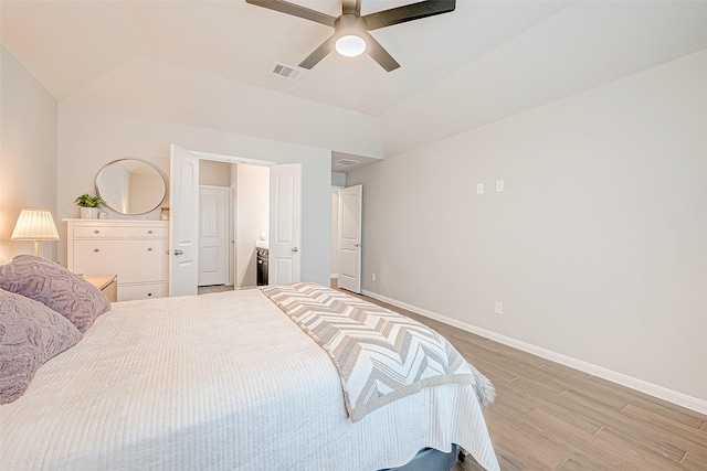 bedroom with light wood-type flooring, vaulted ceiling, and ceiling fan