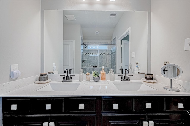 bathroom featuring a shower with door and vanity