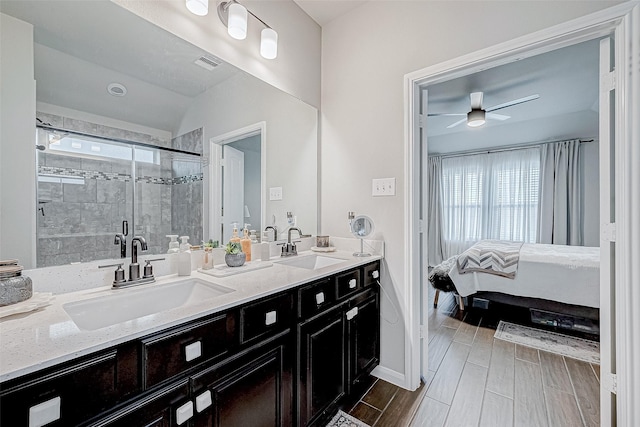 bathroom with a shower with shower door, ceiling fan, and vanity