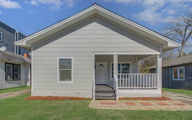 bungalow with covered porch and a front lawn