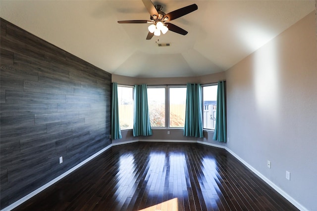 empty room with lofted ceiling, ceiling fan, and dark hardwood / wood-style floors