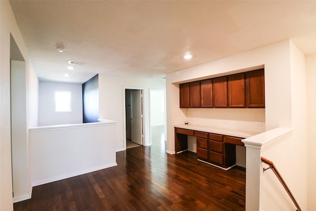 kitchen featuring built in desk and dark hardwood / wood-style floors