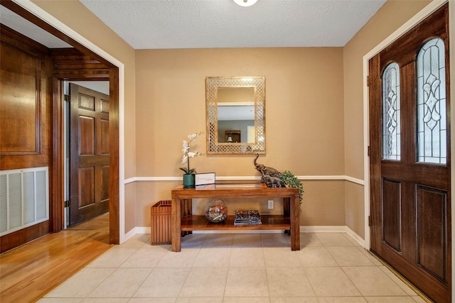 tiled entrance foyer with a textured ceiling