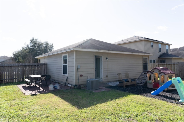 rear view of house with a yard, a patio, a playground, and central air condition unit