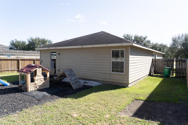 rear view of property featuring a lawn