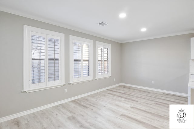 empty room with crown molding and light hardwood / wood-style flooring