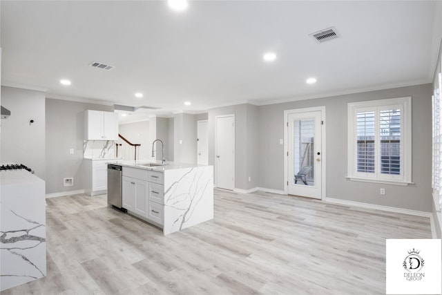 kitchen featuring white cabinets, light stone countertops, and sink