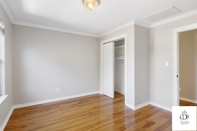 unfurnished bedroom featuring light hardwood / wood-style floors, a closet, and crown molding