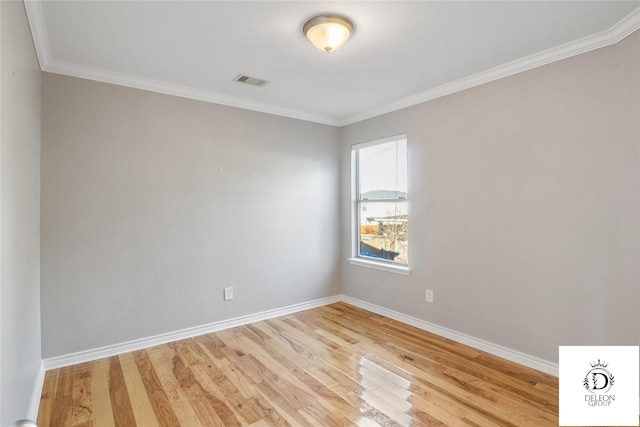 empty room featuring ornamental molding and light hardwood / wood-style flooring