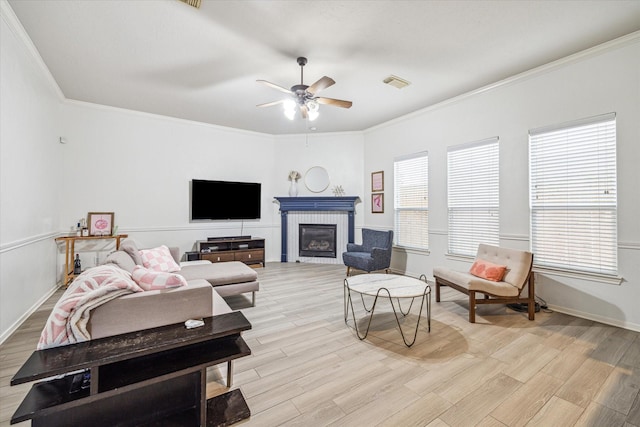 living room featuring crown molding, a wealth of natural light, ceiling fan, and light wood-type flooring