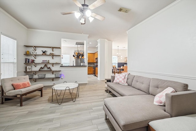 living room with crown molding, ceiling fan with notable chandelier, and light wood-type flooring