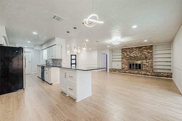 kitchen with pendant lighting, white cabinets, a textured ceiling, stainless steel appliances, and built in features