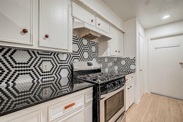 kitchen featuring decorative backsplash, white cabinets, stainless steel gas range, and light wood-type flooring