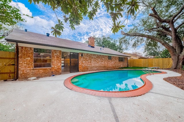 view of swimming pool featuring a patio area and a diving board