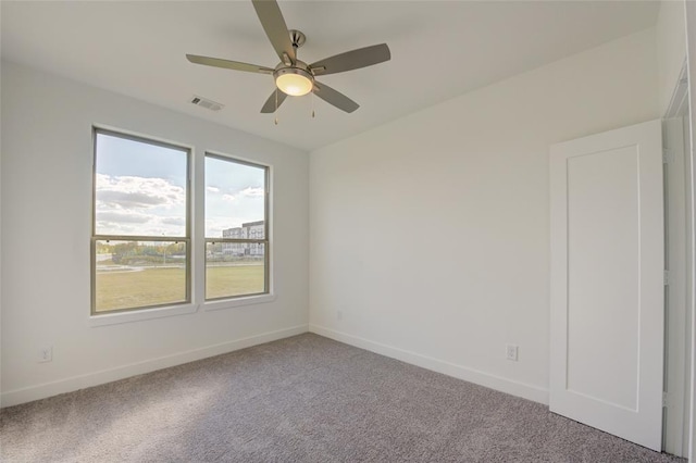 carpeted spare room with ceiling fan