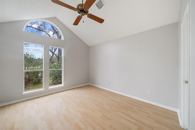 spare room featuring a textured ceiling, ceiling fan, lofted ceiling, and light hardwood / wood-style floors