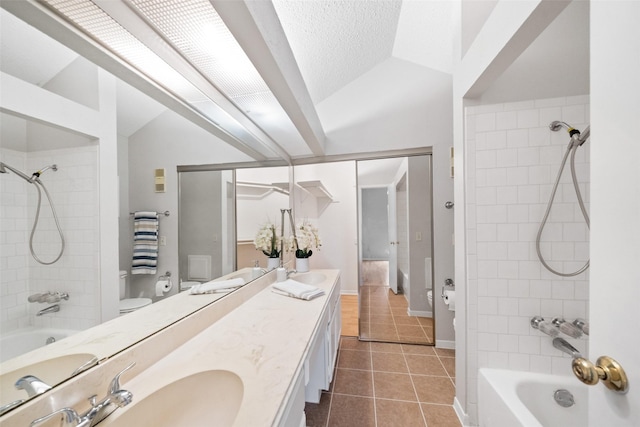 full bathroom featuring vanity, vaulted ceiling, tiled shower / bath combo, and tile patterned floors