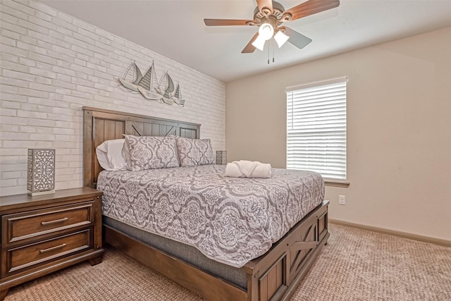 carpeted bedroom with ceiling fan and brick wall