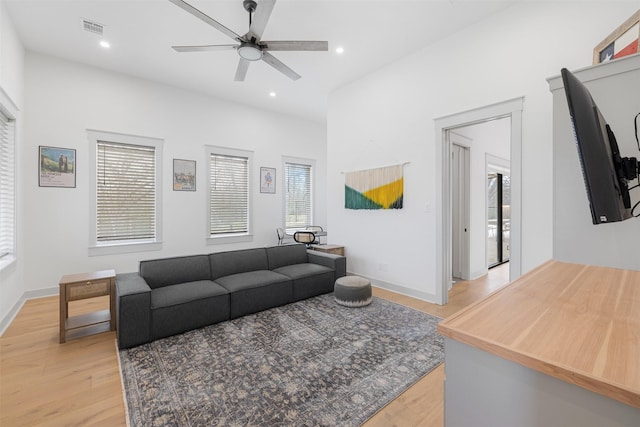 living room featuring ceiling fan and light hardwood / wood-style floors