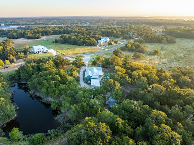 aerial view at dusk featuring a water view