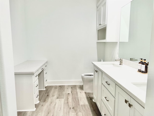 bathroom featuring wood-type flooring, toilet, and vanity