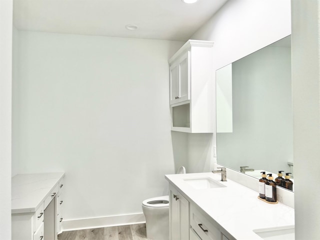 bathroom with wood-type flooring, toilet, and vanity