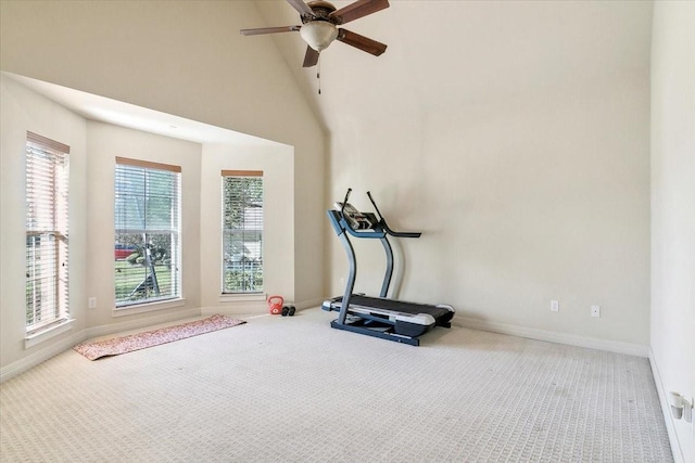 workout room with ceiling fan, carpet flooring, and a high ceiling