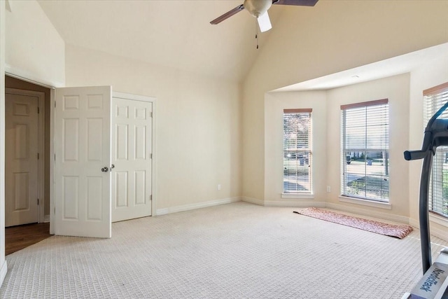 spare room featuring light carpet, ceiling fan, and vaulted ceiling