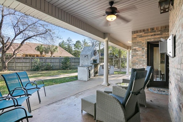 view of patio / terrace featuring ceiling fan and an outdoor stone fireplace