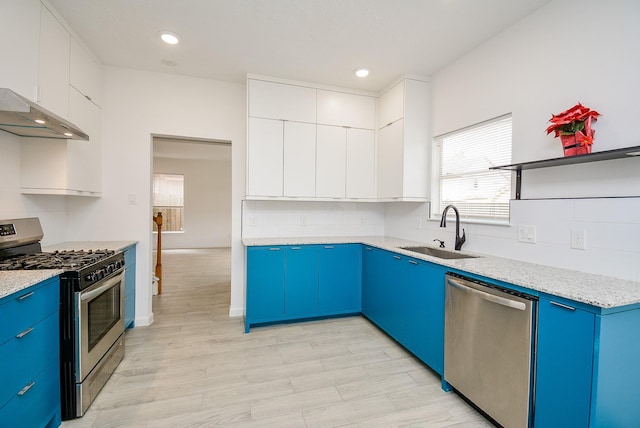 kitchen with white cabinets, appliances with stainless steel finishes, sink, and blue cabinetry