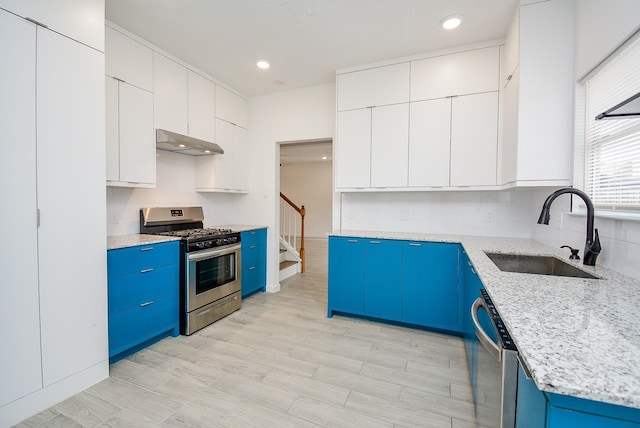 kitchen featuring sink, white cabinetry, light stone countertops, stainless steel appliances, and blue cabinets