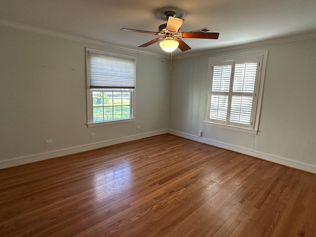 empty room with ceiling fan, crown molding, and hardwood / wood-style floors