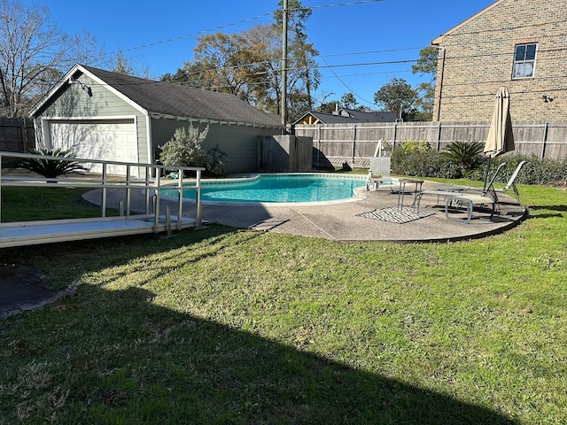 view of swimming pool featuring an outbuilding, a patio area, and a yard