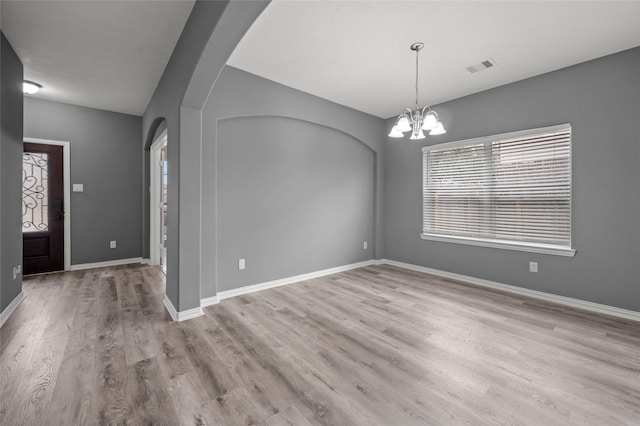 entrance foyer with light hardwood / wood-style flooring and a notable chandelier