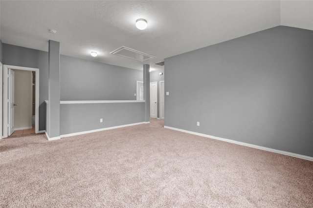 empty room with lofted ceiling, carpet floors, and a textured ceiling