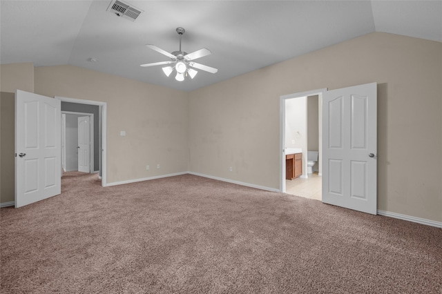 unfurnished bedroom with vaulted ceiling, light carpet, ceiling fan, and ensuite bath