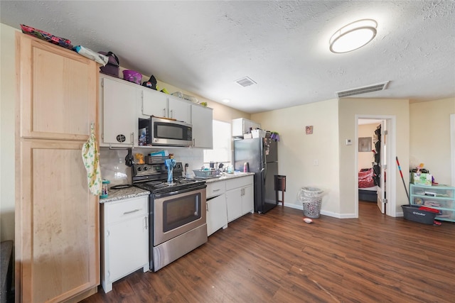 kitchen with white cabinets, dark hardwood / wood-style floors, stainless steel appliances, and a textured ceiling