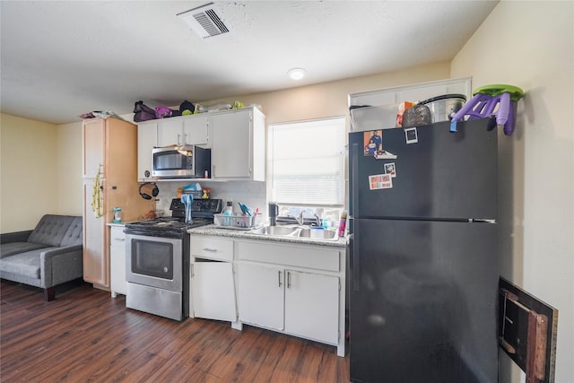 kitchen featuring tasteful backsplash, sink, white cabinetry, stainless steel appliances, and dark hardwood / wood-style flooring