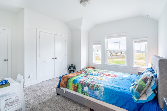 bedroom with a closet, lofted ceiling, and carpet floors