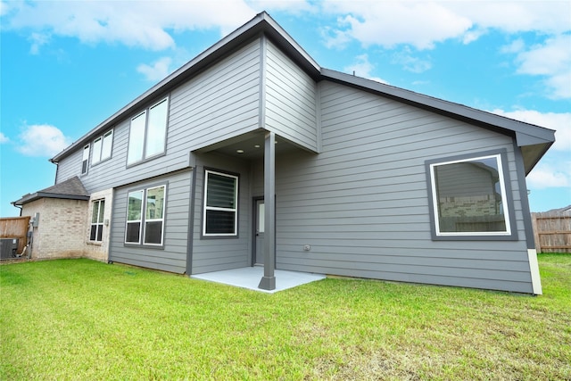 back of property featuring a patio area, cooling unit, and a yard